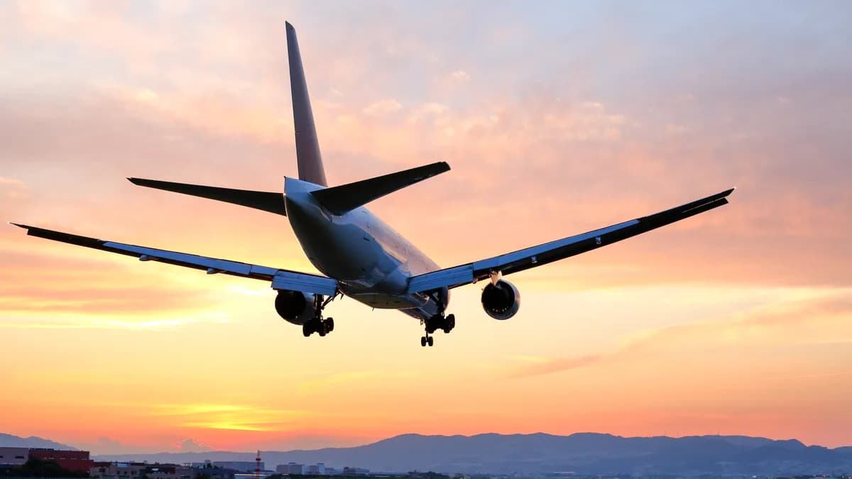 黄金色の夕焼け空と着陸する飛行機