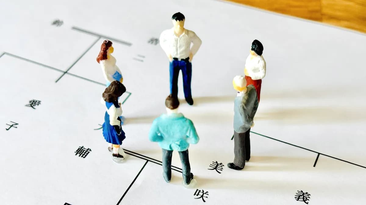 遺産相続について話し合う家族や親族(ミニチュアと家系図)